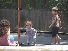 Ryder on the trampoline with mom and Hunter.